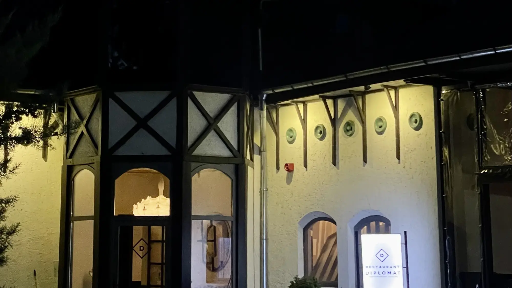 Intrarea Restaurantului Diplomat la ora albastră, cu turnul și ferestrele luminate