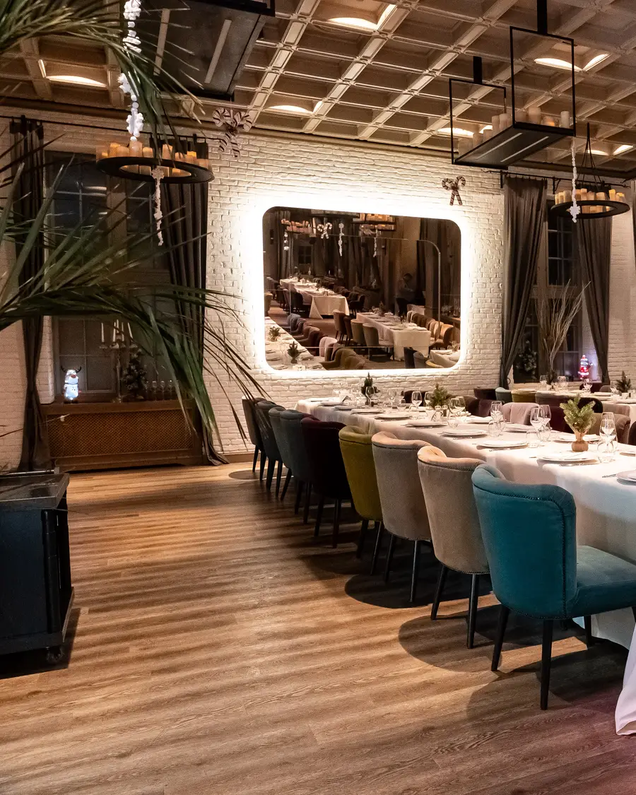 Sala restaurantului seara, cu lumină caldă pe mese